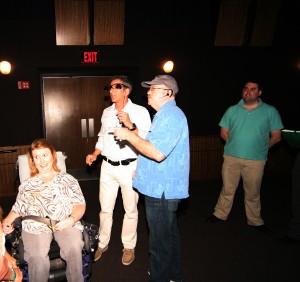 Jenni Gold & Jeff Maynard show Executive Producer David Alfonso the Sony Closed Captioning Glasses.